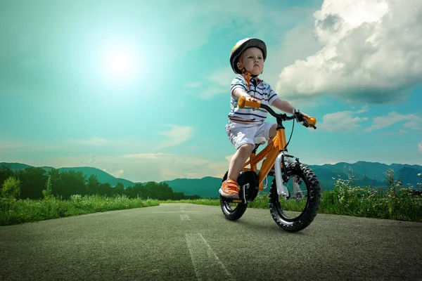 Child on orange bicycle