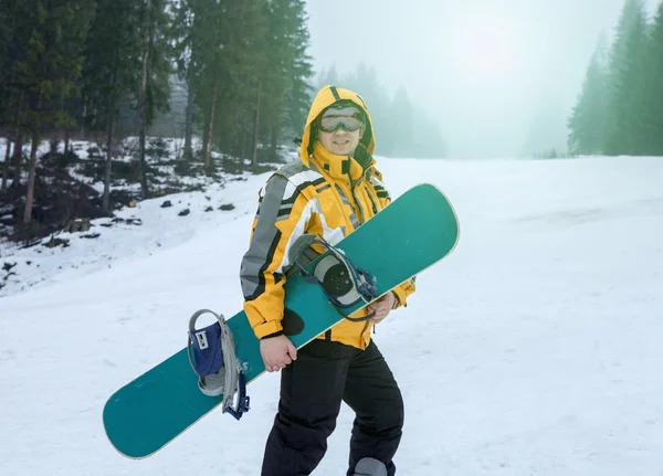 Man in goggles stay with snowboard