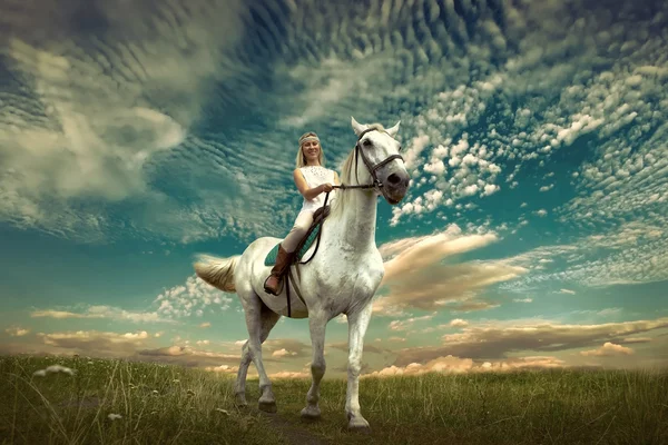 Horsewoman riding on white horse