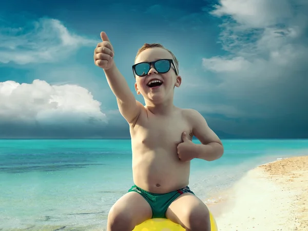 Child in sunglasses fun near the water