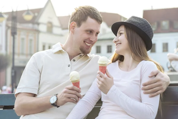 Couple with ice cream sitting at street