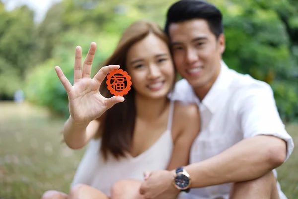 Happy asian couple in love holding symbol