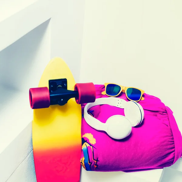 Extreme sports accessories. Skateboard and bright fashionable cl