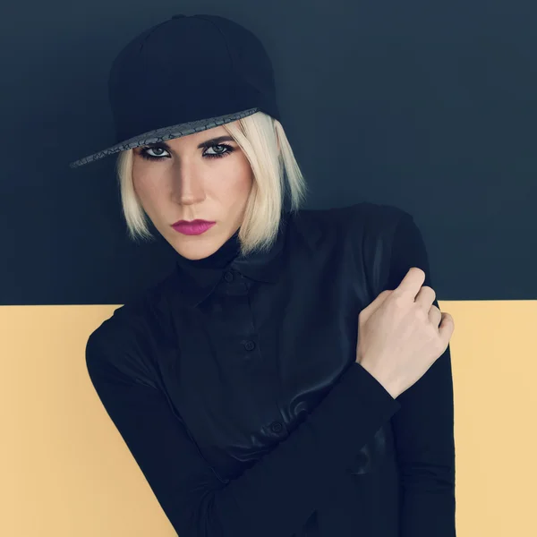 Stylish blonde in black cap and black shirt. Latest fashion tren