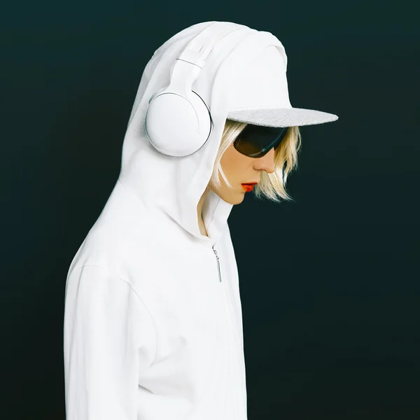 Sensual blonde DJ in sports white clothing listening to Music on