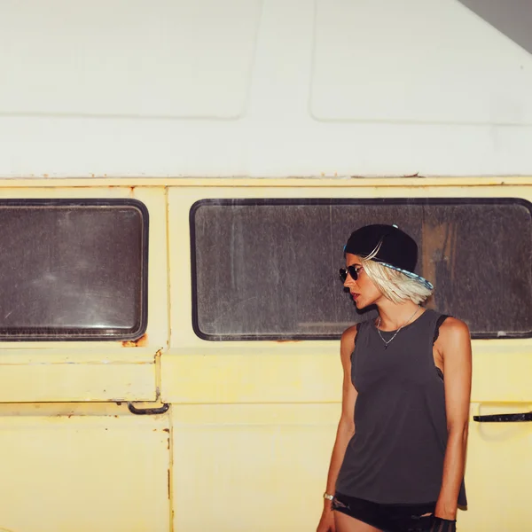 Stylish girl stands near minibus. Surf fashion style