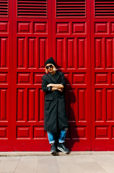 Stylish girl at the red door .Urban fashion style
