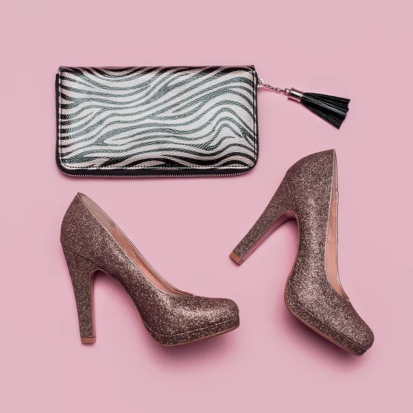 Fashion shoes and clutch on pink background. Gold accent