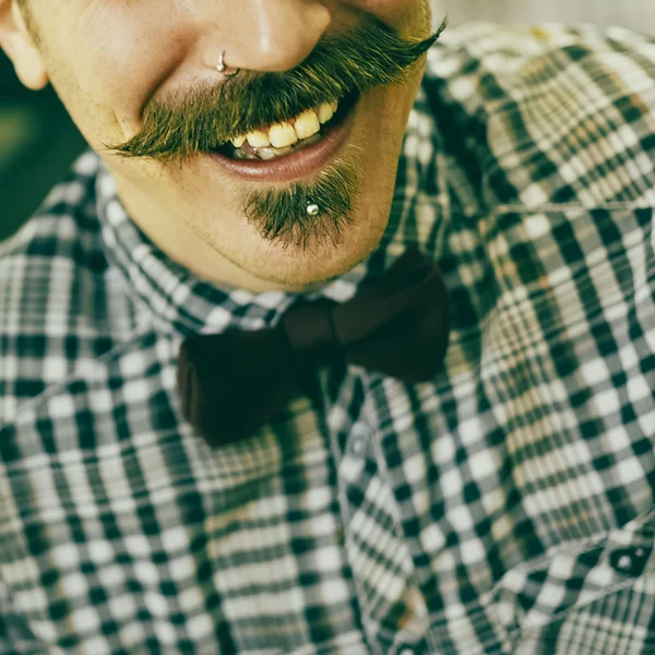 Happy retro man. Bow, checkered shirt and a mustache.