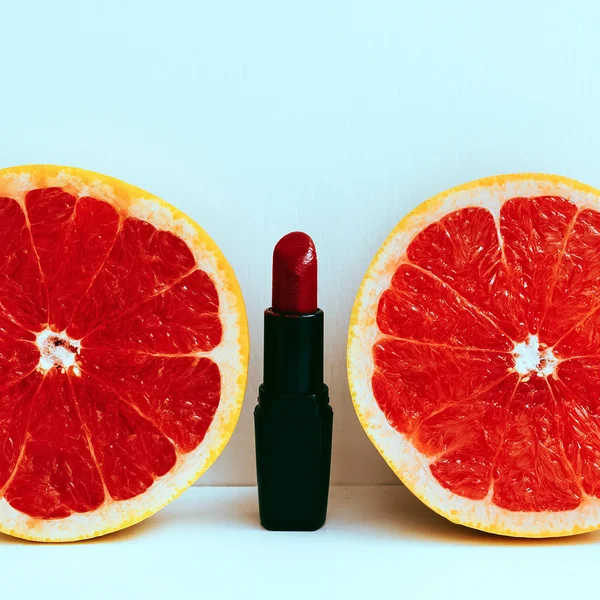 Red accent. Lipstick and grapefruit. minimal photo