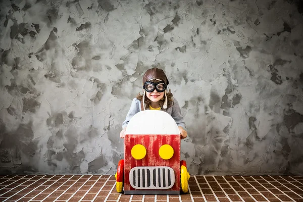 Child driving in a car made of cardboard box