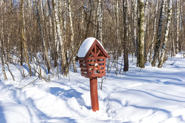 Bird feeder box in the snow covered forest