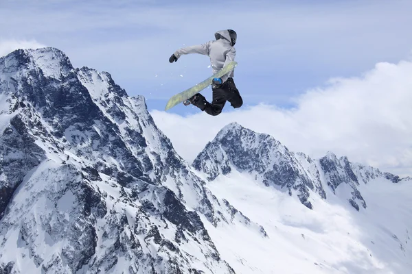 Snowboarder jumping on mountains. Extreme sport.