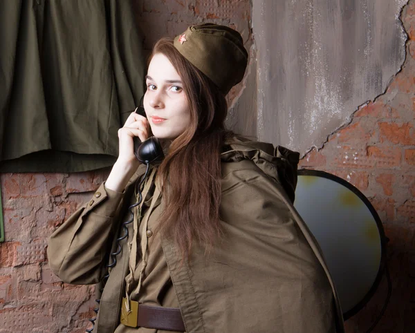 Woman in Russian military uniform speaks on phone. Female soldier during the second world war.