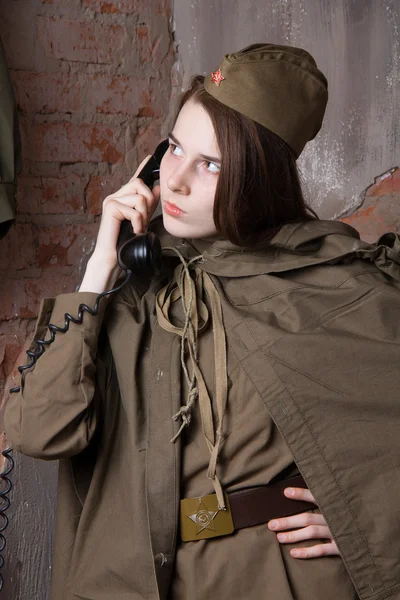 Woman in Russian military uniform speaks on phone. Female soldier during the second world war.