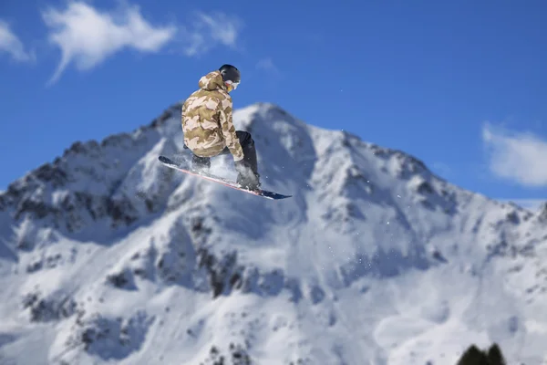 Snowboard rider jumping on mountains. Extreme snowboard freeride sport.