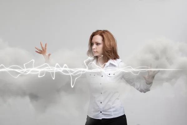 Woman making magic effect - flash lightning. The concept of electricity, high energy.