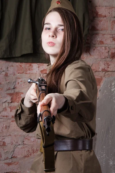 Woman in Russian military uniform shoots a rifle. Female soldier during the second world war.