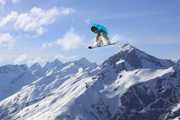 Snowboarder jumping on mountains. Extreme sport.