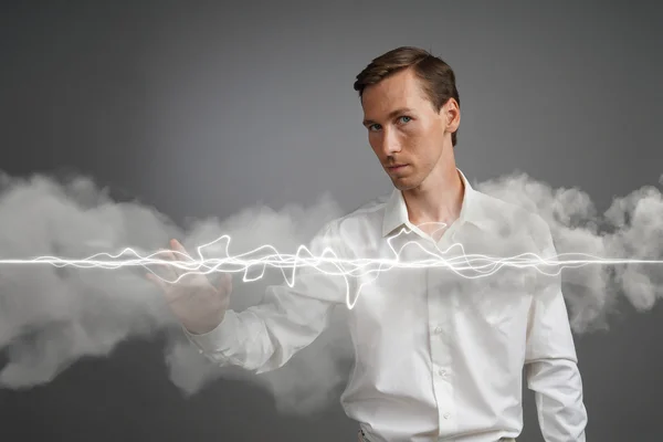 Man in white shirt making magic effect - flash lightning. The concept of electricity, high energy.