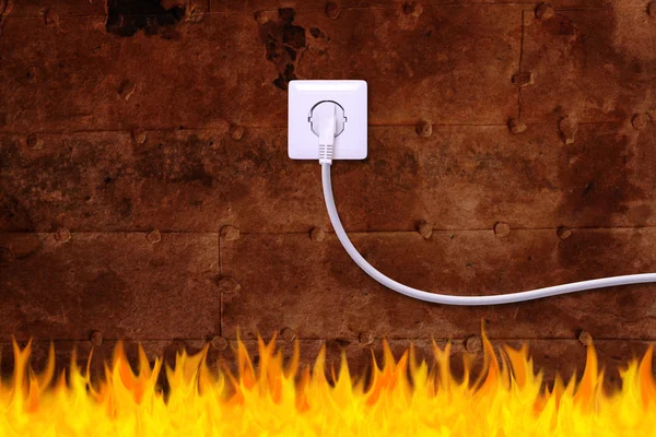 Rusty iron wall with an electrical outlet and fire