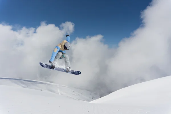 Flying snowboarder on mountains