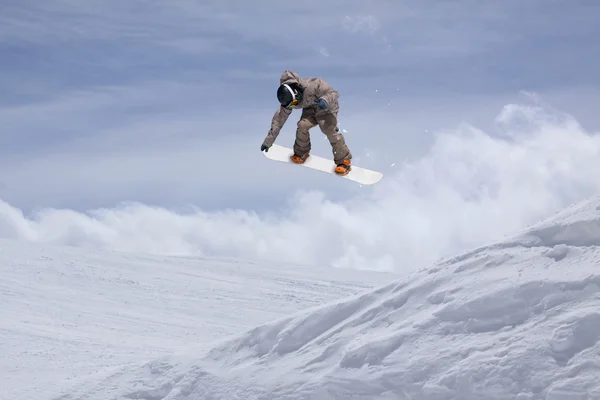 Flying snowboarder on mountains. Extreme sport.