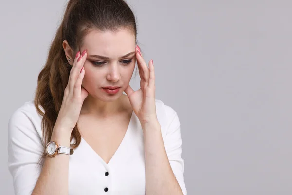 Beautiful young woman with headache touching her temples