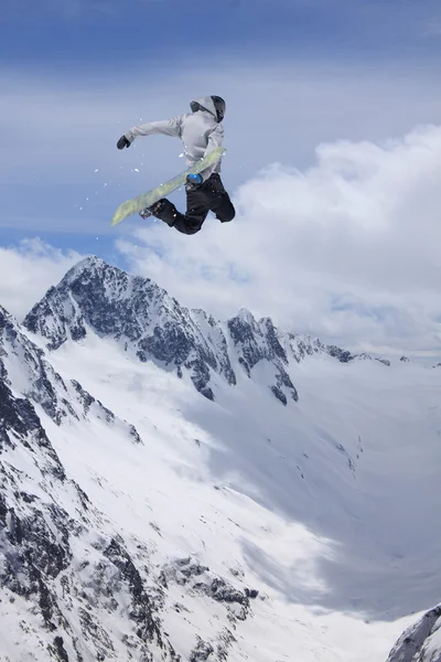 Flying snowboarder on mountains. Extreme sport.