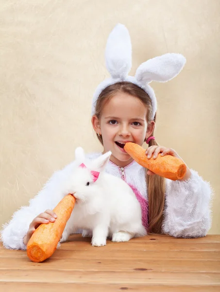 Bunnies eating large carrots