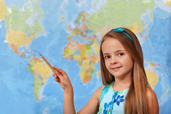 Little student girl pointing to blurry world map