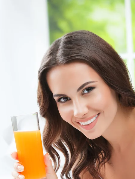Happy smiling young woman drinking orange juice