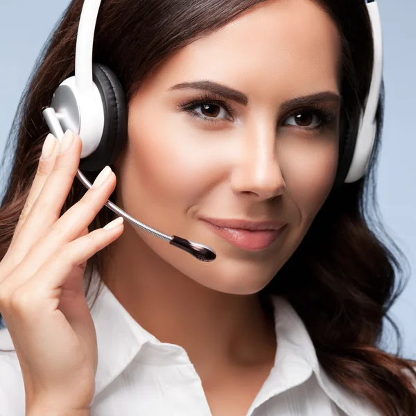 Portrait of customer support female phone worker, on grey