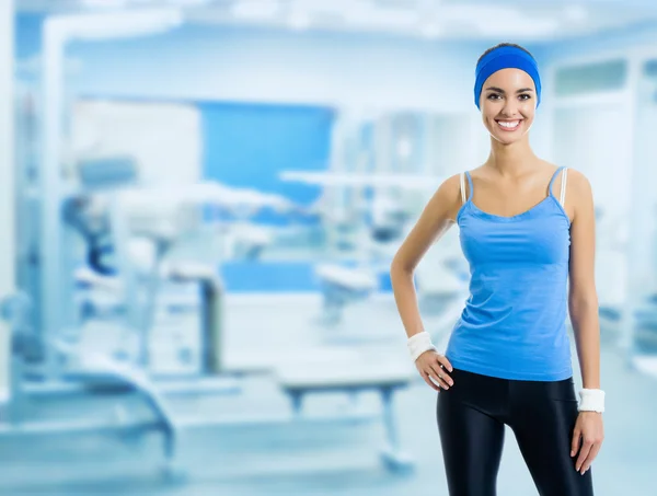 Happy smiling woman in sportswear, at gym