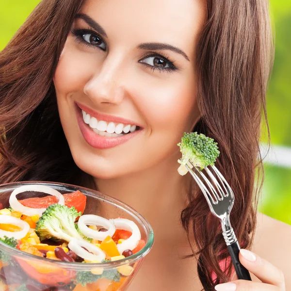 Brunette woman with vegetarian vegetable salad