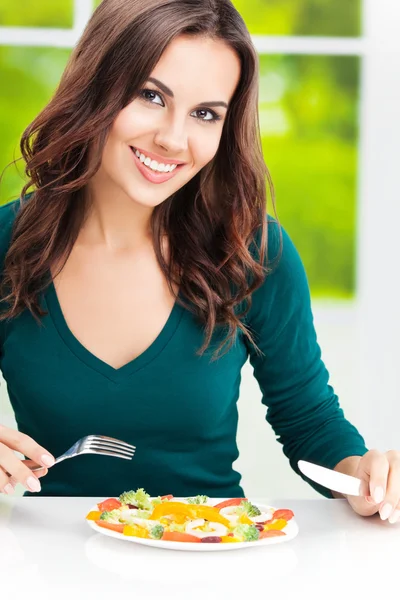 Brunette woman with vegetarian vegetable salad
