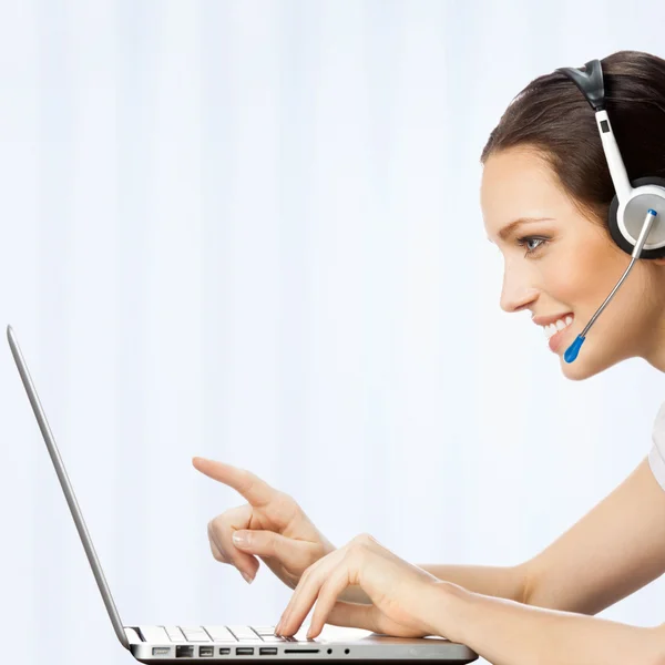 Phone operator in headset with laptop, at office