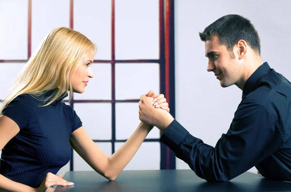 Couple or two businesspeople fighting in arm wrestling