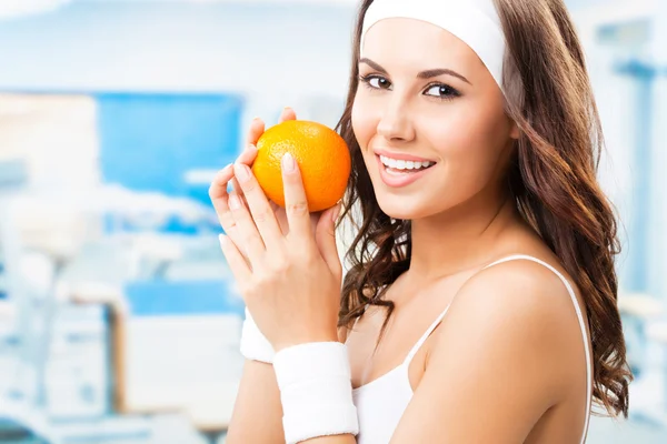 Woman with orange, at gym