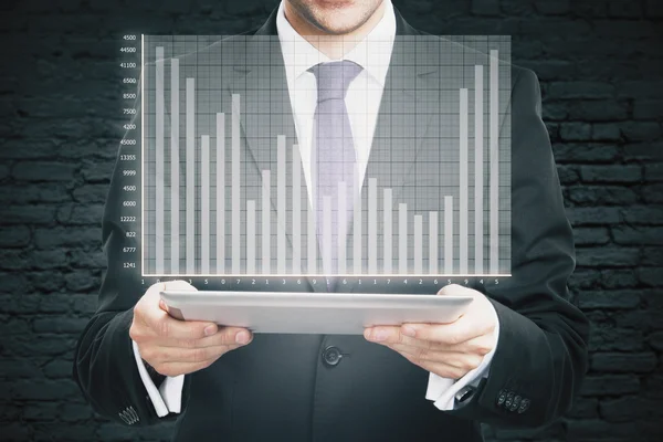 Businessman holding tablet with graph