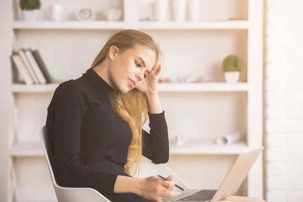 Thoughtful lady using laptop