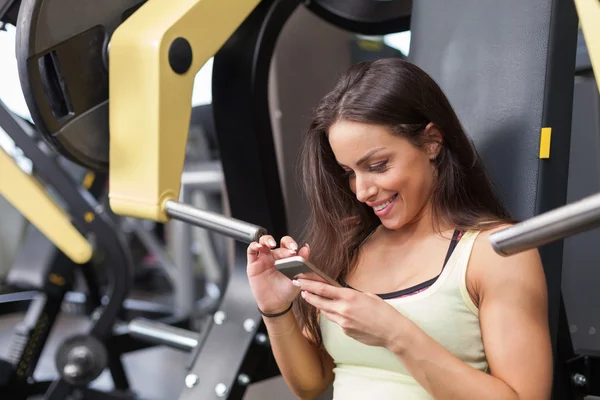 Woman using mobile phone on a break in health club