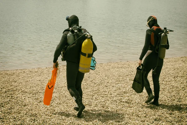 Couple wearing diving equipment in the water