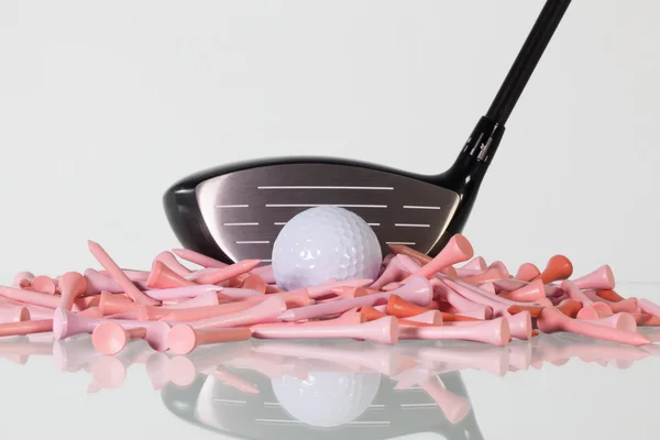 Golf driver and wooden tees on a glass desk