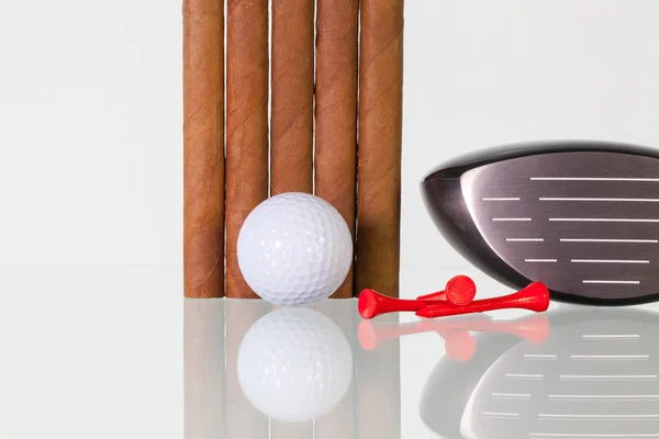 Golf driver and different cigars on a glass desk