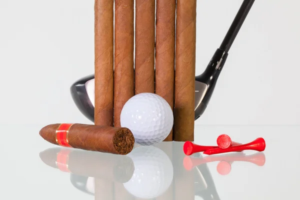Golf driver and different cigars on a glass desk