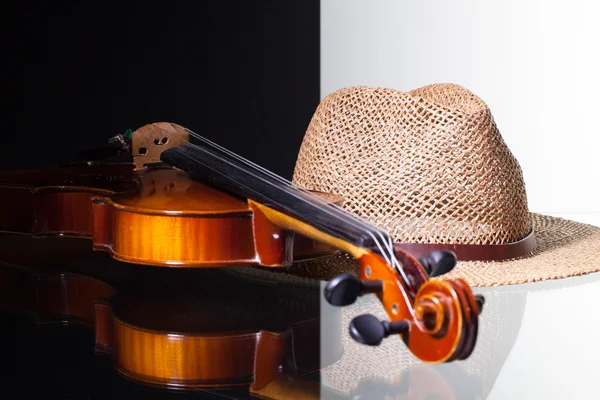 Old violin and straw hat isolated on black and white background