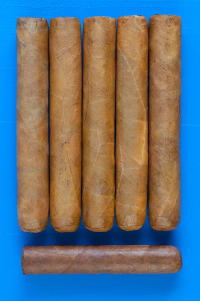 Detail of luxury Cuban cigars on the blue desk
