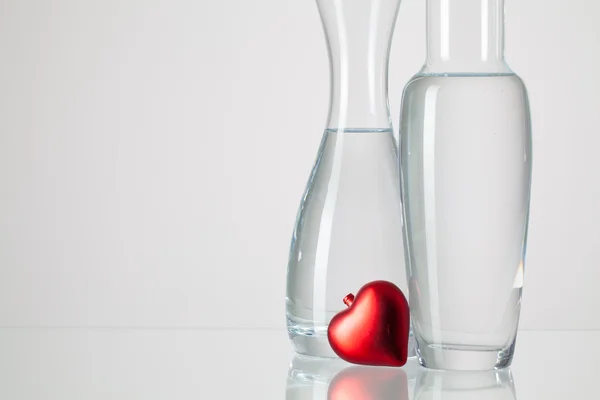 Two vases with clean water and red heart