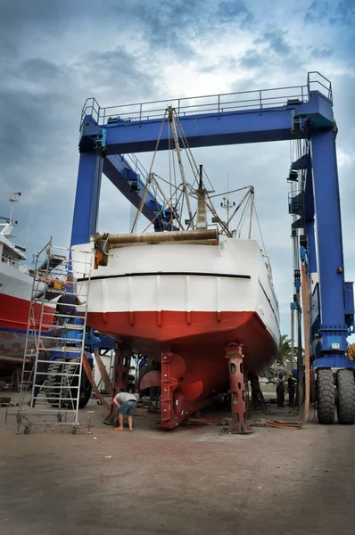 Workers repairing a fishing boat